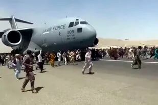 Una imagen que ya se volvió símbolo: el 16 de agosto de 2021, cientos de personas corren al lado de un avión de carga C-17 de la Fuerzas Aérea de Estados Unidos que trata de despegar en la pista del aeropuerto internacional de Kabul, Afganistán