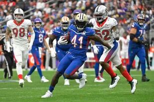 El running back de la NFC Alvin Kamara, de los saints de Nueva Orleans, deja atrás al linebacker de la AFC Denzel Perryman, de los Raiders de Las Vegas, en la primera mitad del Pro Bowl, el domingo 6 de febrero de 2022, en Las Vegas. (AP Foto/David Becker)