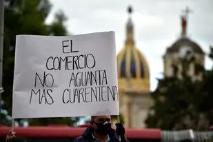 Comerciantes con mascarillas participan en una protesta contra los nuevos bloqueos impuestos por la alcaldesa de Bogotá, Claudia López, pidiendo el fin de la cuarentena, en el marco de la pandemia del coronavirus, en Bogotá el 24 de agosto de 2020