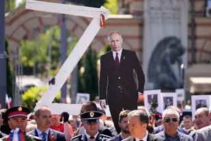 Personas sostienen una imagen del presidente ruso Vladimir Putin y una letra Z, durante la ceremonia del Día de la Victoria en Belgrado, Serbia, el lunes 9 de mayo de 2022.