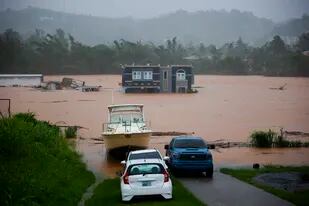 Personas dentro de una casa esperan ser rescatadas de las inundaciones causadas por el huracán Fiona en Cayey, Puerto Rico