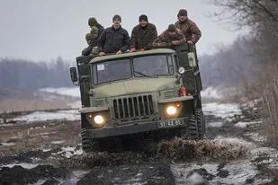 Soldados ucranianos, a bordo de un camión en una carretera enlodada durante maniobras en la región de Donetsk, en el este del país, el 10 de febrero de 2022. (AP Foto/Vadim Ghirda)