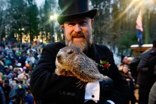 PUNXSUTAWNEY, PA - FEBRUARY 02: Groundhog handler AJ Derume holds Punxsutawney Phil, who saw his shadow, predicting a late spring during the 136th annual Groundhog Day festivities on February 2, 2022 in Punxsutawney, Pennsylvania. Groundhog Day is a popular tradition in the United States and Canada. A crowd of upwards of 5000 people spent a night of revelry awaiting the sunrise and the groundhog's exit from his winter den. If Punxsutawney Phil sees his shadow he regards it as an omen of six more weeks of bad weather and returns to his den. Early spring arrives if he does not see his shadow, causing Phil to remain above ground.  (Photo by Jeff Swensen/Getty Images)