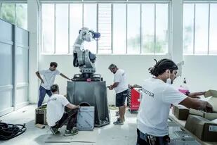 Operarios ensamblan un robot que esculpe en mármol en la empresa Torart, en Carrara, Italia, el mes pasado