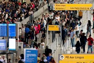 ARCHIVO - La gente espera en la fila de la Administración de Seguridad del Transporte (TSA) en el Aeropuerto Internacional John F. Kennedy el 28 de junio de 2022, en Nueva York. (AP Foto/Julia Nikhinson, Archivo)