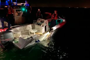 Un miembro de la Guardia Costera inspecciona una embarcación que colisionó con otra cerca de cayo Vizcaíno, en Florida, la noche del viernes 17 de junio de 2022. En el incidente, 2 personas murieron y 10 fueron rescatadas con vida, según las autoridades. (Guardia Costera de Estados Unidos vía AP)