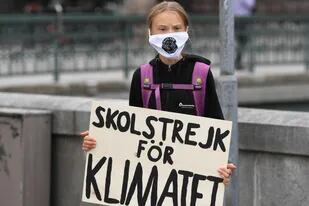 La activista climática sueca Greta Thunberg sostiene un cartel que dice "Huelga escolar por el clima" mientras protesta frente al Parlamento sueco Riksdagen