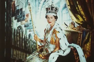 Retrato de la reina Isabel en su coronación, quien posa con el cetro con la cruz y el orbe, una esfera de oro con gemas, que simboliza su rol de defensora de la fe (Crédito: Cecil Beaton/Museo Victoria & Albert)