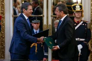 Los ministros de economía de la Argentina y de Brasil, tras firmar un acuerdo para el financiamiento de importaciones