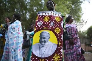 Una mujer sursudanesa sostiene una tela estampada que muestra el retrato del Papa Francisco mientras continúan los preparativos antes de su visita en Juba, el 30 de enero de 2023.
