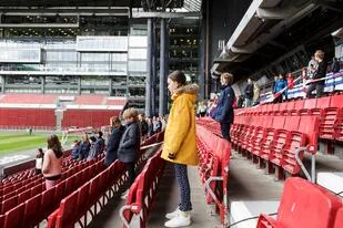 Los alumnos se sientan en las gradas, manteniendo la distancia social, antes de una clase al aire libre celebrada en el estadio Telia Parken debido a la pandemia de coronavirus el 15 de mayo de 2020 en Copenhague