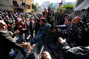 Manifestantes opositores al gobierno chocan con policías antidisturbios afuera del Palacio de Justicia, en Beirut, Líbano, el jueves 26 de enero de 2023. (AP Foto/Hassan Ammar)