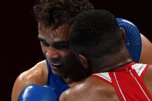 El boxeador marroquí Youness Baalla, de rojo, intenta morderle la oreja al neozelandés David Nyika durante el combate de los pesados