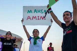 Una mujer sostiene un cartel con el nombre de Mahsa Amini, una mujer que murió mientras estaba detenida por la policía en Irán, durante una protesta después del un partido del Grupo B del Mundial entre Gales e Irán, en el estadio Ahmad Bin Ali en Rayán, Qatar