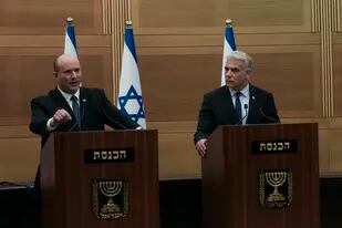 El primer ministro de Israel, Naftali Bennett (izquierda), ofrece una conferencia de prensa conjunta con el ministro de Exteriores, Yair Lapid, en el Knesset, el parlamento israelí, en Jerusalén, el 20 de junio de 2022. (AP Foto/Maya Alleruzzo)
