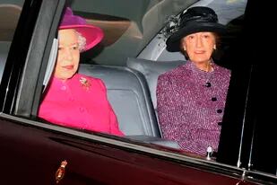 La reina Isabel II de Gran Bretaña y su entonces dama de compañía, Lady Susan Hussey, llegan a la iglesia de Santa María Magdalena, en la finca real de Sandringham en Norfolk, Inglaterra, el 23 de enero de 2011.