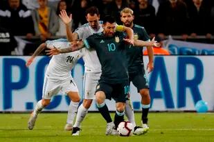 Lionel Messi en un duelo clásico ante el duro defensro uruguayo Diego Godin