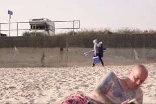 El video muestra a un hombre encapuchado, supuestamente Banksy, dirigiéndose a realizar una obra en la playa