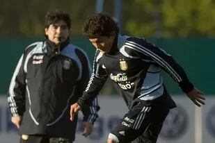 El Pulga toca el balón con su zurda, ante la mirada de Maradona, el DT del seleccionado en 2009