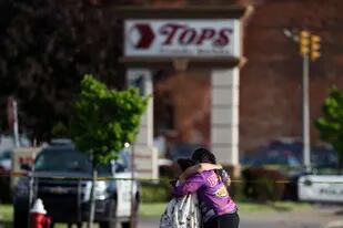 Un par de personas se abraza afuera del supermercado donde se registró un tiroteo el sábado 14 de mayo de 2022, en Buffalo, Nueva York. (AP Foto/Joshua Bessex)