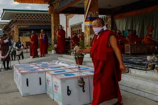 Monjes del organismo monástico de Paro realizaron un rito cuando 500.000 dosis de la vacuna de Moderna llegaron desde Estados Unidos al Aeropuerto Internacional de Paro, Bhutan, 12 de julio (UNICEF via AP)