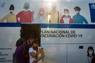 Mujeres salen de un ómnibus que se usa para inyectar la vacuna contra Covid-19 en Santiago, Chile