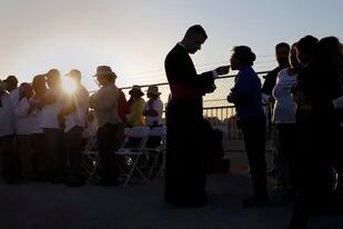 ARCHIVO - Migrantes que asisten a la misa del papa Francisco en Ciudad Juárez, México, comulgan en un terraplén a orillas del río Bravo en El Paso, Texas, 17 de febrero de 2016. (AP Foto/Eric Gay, File)