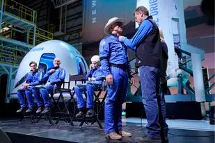 ARCHIVO – Desde la izquierda, Oliver Daemen, Mark Bezos y Wally Funk presencian cuando Jeff Bezos, segundo desde la derecha, recibe su insignia de alas de astronauta elaborada por Blue Origen, de manos del exastronauta de la NASA, Jeff Ashby, a la derecha, quien ahora está con Blue Origen, durante una conferencia de prensa posterior al lanzamiento de New Shepard, en el puerto espacial cerca de Van Horn, Texas, el 20 de julio de 2021. (AP Foto/Tony Gutierrez)