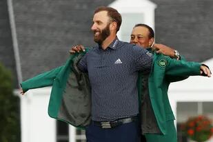 Tiger Woods le coloca el saco verde al ganador del Masters de Augusta, Dustin Johnson.