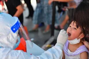 Un trabajador de la salud recolecta una muestra de hisopado  en la comunidad de Huayuan de Baisha,