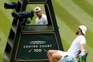 Rafael Nadal y Matteo Berrettini hablan durante la práctica que tuvieron en la cancha central de Wimbledon, que comenzará el próximo lunes.