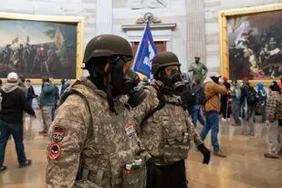 Los partidarios del presidente de Estados Unidos, Donald Trump, usan máscaras de gas y ropa de estilo militar mientras caminan dentro de la Rotonda después de ingresar al Capitolio de los Estados Unidos en Washington, DC, 6 de enero de 2021