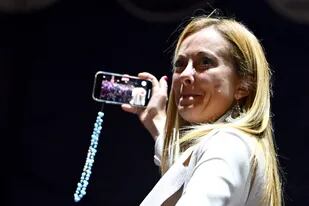 Giorgia Meloni hace un video selfie tras su discurso en el cierre de campaña en la Piazza del Popolo, en Roma. (Alberto PIZZOLI / AFP)
