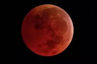 Durante un eclipse lunar total, la luz del sol es filtrada por la atmósfera de la Tierra y por ello la Luna se torna de una tonalidad anaranjada