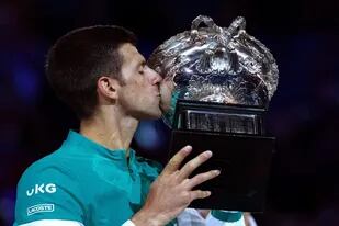 El serbio Novak Djokovic besando el trofeo del Australian Open después de derrotar al ruso Daniil Medvedev en la final: el serbio sumó su 18° título de Grand Slam.
