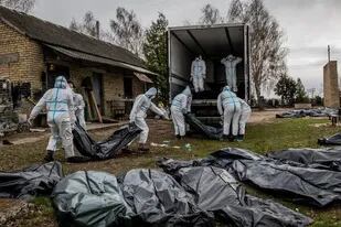 Voluntarios cargando a los muertos en un camión en Bucha, Ucrania, el martes