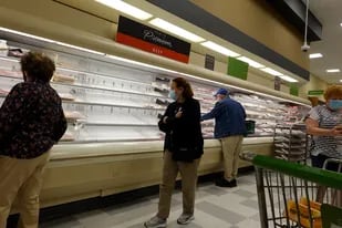 Los estantes que exhiben carne están parcialmente vacíos mientras los compradores recorren un supermercado el 11 de enero de 2022 en Miami, Florida.