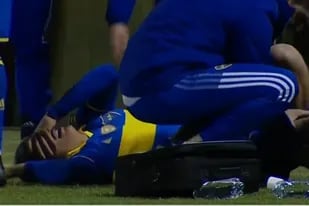 Exequiel Zeballos, a puro dolor en el piso mientras recibe atención médica; el delantero de Boca tuvo que salir