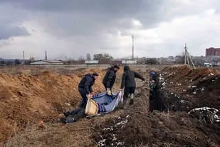 Los cadáveres son depositados en una fosa común en las afueras de Mariupol, Ucrania, el miércoles 9 de marzo de 2022, ya que la gente no puede enterrar a sus seres queridos debido al fuerte bombardeo de las fuerzas rusas.