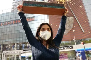 La activista climática Xiye Bastida sostiene un reloj, debajo del Reloj Climático, después de una conferencia de prensa con huelguistas juveniles, comunidades afectadas por el clima y activistas de justicia ambiental y climática que viajarán a Washington, DC para entregar un reloj portátil a los funcionarios de la administración de Biden en Union Square Nueva York el 19 de abril de 2021