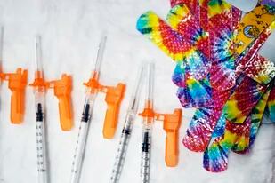 Esta fotografía muestra jeringas y bandas adhesivas sanitarias de colores antes de una sesión de vacunación contra el COVID-19 para niños de escuelas locales, el lunes 13 de diciembre de 2021, en Pittsfield, Massachusetts.  (Ben Garver/The Berkshire Eagle vía AP, archivo)