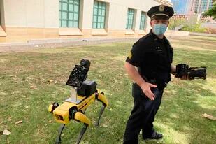El teniente de la policía de Honolulu, Joseph O'Neal, demuestra un perro robot en Honolulu, 14 de mayo de 2021. Los agentes que utilizan de manera experimental las máquinas de cuatro patas dicen que son una herramienta más, como los drones, para evitar que los socorristas corran peligro en situaciones de emergencia. (AP Foto/Jennifer Sinco Kelleher)