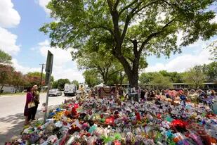 Nogales plantados en la década de 1960 cubren con su sombra un monumento conmemorativo improvisado en honor de las víctimas de la reciente masacre en la Escuela Primaria Robb, el jueves 9 de junio de 2022, en Uvalde, Texas. (AP Foto/Eric Gay)