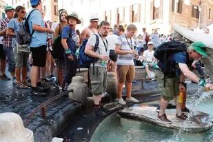 Filas de turistas llenan sus botellas en la Plaza de España, de Roma, para combatir la ola de calor