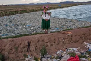 La activista ambientalista Maruja Inquilla posa para una foto junto a una planta municipal de tratamiento de residuos con agua que desemboca en el Lago Titicaca, en Juliaca, en la región de Puno, Perú