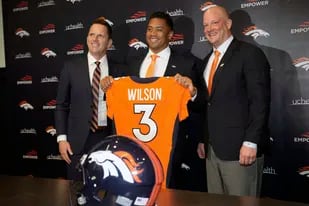 El nuevo quarterback de los Broncos de Denver Russell Wilson posa con el entrenador Nathaniel Hackett y el gerente general George Paton tras la conferencia de prensa el 16 de marzo del 2022. (AP Foto/David Zalubowski)