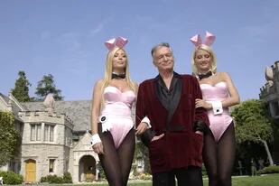 Kendra Wilkinson y Holly Madison junto a Hugh Hefner, con la mansión Playboy de fondo (Getty)