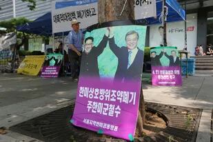 Fotos que muestran al líder norcoreano Kim Jong Un, a la izquierda, y al presidente de Corea del Sur, Moon Jae-in; Los letreros leen: "Retiro de las tropas de los EE. UU."