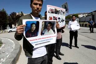 Turcos uigures que dicen no haber tenido noticias de sus familiares asisten a una protesta cerca de la embajada china, en Ankara, Turquía, el martes 24 de mayo de 2022.