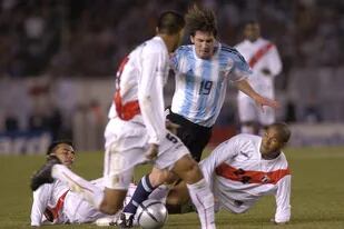 Tres jugadores peruanos intentan controlar a Messi: la acción se repetirá mañana, pero la foto pertenece a octubre de 2005, la noche del primer partido del rosarino en el país; con el 19 en la camiseta y botines de la marca "archirrival" de la que luego sería modelo